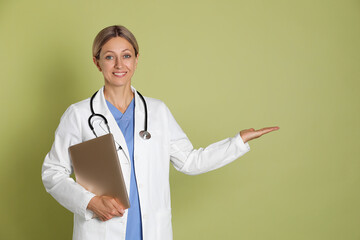 Sticker - Doctor in medical uniform with stethoscope and laptop on light green background