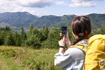 Canvas Print - Young hiker taking picture with smartphone in forest