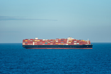 Large container vessel, fully loaded with containers, spotted near US coast on her way to the container terminal in New York port.