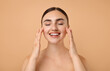 © New Africa - Face massage. Beautiful young woman with healthy skin on beige background