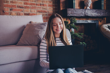 Wall Mural - Photo of attractive teen female sit floor netbook dressed striped outfit cozy day light home interior living room