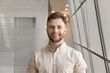 © fizkes - Happy young Caucasian businessman posing for portrait, looking at camera, smiling, posing in office business center space. Handsome entrepreneur, professional, manager screen view head shot