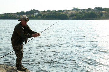 Sticker - Fisherman with rod fishing near lake at summer, space for text