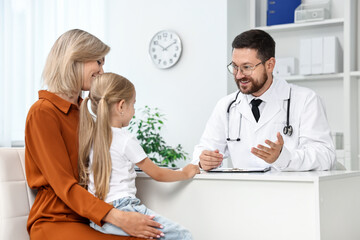 Canvas Print - Doctor consulting little girl and her mother in hospital