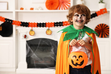 Sticker - Funny boy with bucket dressed like pumpkin in room, space for text. Halloween celebration