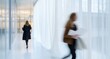 © SKIMP Art - Two people walking in an office building corridor, one person is holding papers and the other has their phone to their , white curtains blowing gently across them, blurry background Generative AI