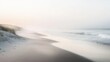 © Валерий Тодаренко - A quiet, foggy beach at dawn, the soft sand stretching out towards gentle waves lapping at the shoreline under a pale sky.