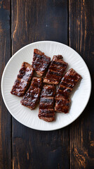 Juicy grilled steak slices with grill marks are resting on a white plate over a dark wooden background