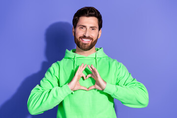 Poster - Photo portrait of handsome mature age funky man wearing bright green hoodie showing respect and love symbol isolated on violet color background