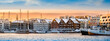 © Julia Lavrinenko - Tromso harbor at sunset in winter, Norway. View of Scandinavian buildings and boats in port of Tromso. Snowy winter landscape in arctic circle town in far northern Norway
