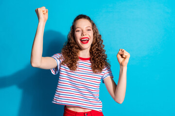 Poster - Joyful young woman with curly hair celebrating against blue background