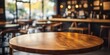 © JW Studio - A close-up of a round wooden table inside a cozy cafe, with warm ambient lighting, ideal for food photography, coffee culture, or interior design projects