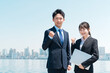 © buritora - 就職・転職・リクルート・青空の中に立つスーツ姿の男女・ビジネスマンとビジネスウーマン