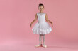 © New Africa - Little ballerina practicing dance moves on pink background