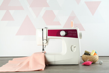 Sticker - One sewing machine with fabric and tools on wooden table indoors