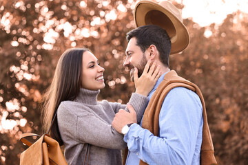 Wall Mural - Beautiful couple spending time together outdoors on autumn day