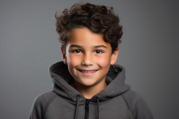 Portrait of a cute little boy with curly hair in hoodie