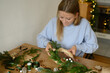 © Franci Leoncio - Woman crafting a handmade Christmas wreath