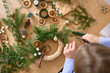 © Franci Leoncio - Person arranging decorations for a natural Christmas wreath
