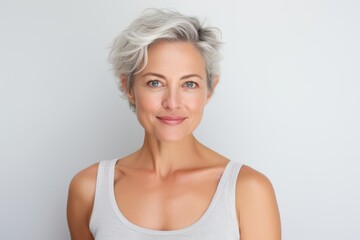 Portrait of beautiful middle aged woman with grey hair smiling at camera