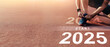 © Urupong - New year 2025 concept, beginning of success. Text 2025 written on asphalt road and male runner preparing for the new year. Concept of challenge or career path and change.