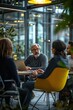 © Georgii - A group of business professionals engaged in an open discussion at a modern office with natural lighting and greenery