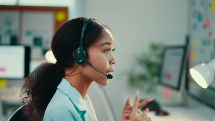 Aufkleber - African american woman wearing a headset engages in conversation while seated at her desk in a modern office environment, providing customer support and assistance