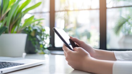 Poster - Hands Holding Smartphone and Laptop on a Table
