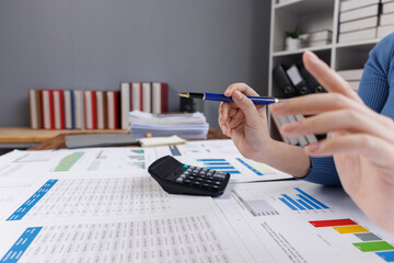 Close up of businesswoman uses a calculator to calculate business principles. Accounting statistical concepts at the office starting a financial business, calculating accounting online marketing.
