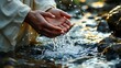 © Ruslan Abdullin - Hands cupping water from a stream, symbolizing purity and connection with nature
