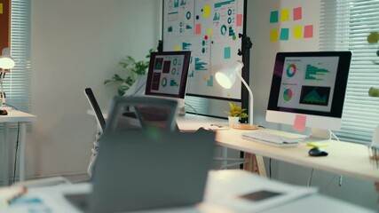 Aufkleber - Nobody is working at a desk in a small startup business office. A computer screen on a desk shows charts and data visualizations