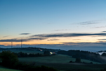 Wall Mural - wind turbines and rural landscape at sunrise