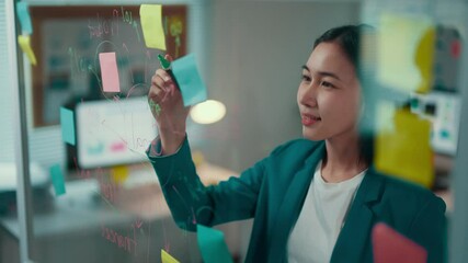 Aufkleber - Businesswoman utilizes colorful sticky notes on a glass wall for planning a business strategy