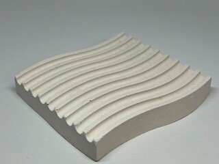 Poster - A textured white object with wavy grooves, likely used for design or artistic purposes.