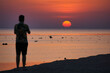 © ukasz - Beautiful sunrise on Red Sea, Marsa Alam, Egypt, July 2023 - outline of the boat, umbrellas, beach, chillout in the morning. Silhouettes of people against the background of sunrise