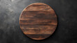 © suldev - On black table, circular wooden tray or cutting board. Top view of barren kitchen with saw-cut imitation trendy rustic wooden tray.