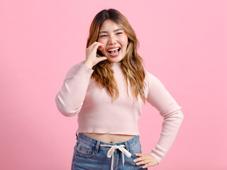 Half body photo cute happy fun young Asian beautiful female, woman smiling in light pink long-sleeve shirt poses isolated plain pastel light over pink color wall background