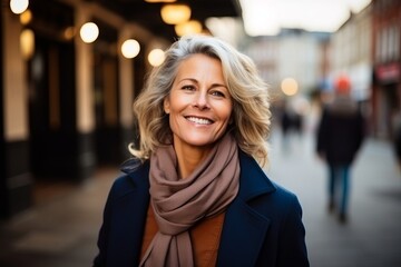 Portrait of a happy senior woman walking in the city at dusk