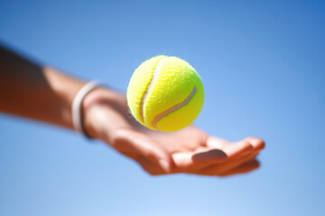 A person is holding a tennis ball in their hand