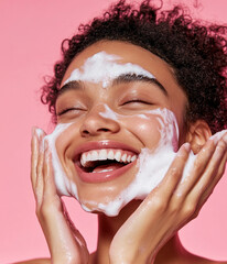 Wall Mural - Young smiling black woman washing her face with foam cleanser.