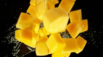 Fototapete - Super Slow Motion of Falling Mango Slices into Water, Black Background. Filmed on High Speed Cinema Camera, 1000 fps. Camera Tracking the Target.