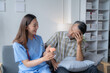 © Tj - Young doctor is showing a brain model to her senior patient during a home visit, explaining brain anatomy and functions