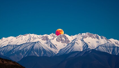 Poster - A wide panoramic shot of a majestic mountain range with the lunar eclipse above. 