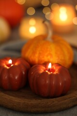 Sticker - Burning candles and pumpkin against blurred lights, closeup. Autumn atmosphere