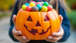 © Laura - hands holding a halloween jack o lantern with candies
