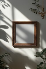 Poster - Empty wooden frame hanging on a wall in a sunlit room with shadows from nearby plants