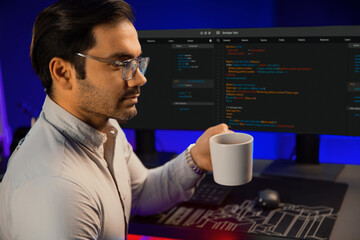 Smart IT developer drinking coffee cup while working in software development coding on pc screen, presenting program application update online website database at neon lighting cyber office. Surmise.