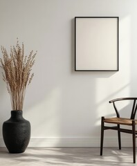 Poster - A minimalist interior features a black-framed empty canvas, dried plants in a vase, and a wooden chair against soft sunlight shadows.