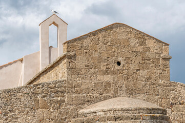 A seagull on the bell tower of the ancient church of Sant'Efisio in Nora, Sardinia, Italy