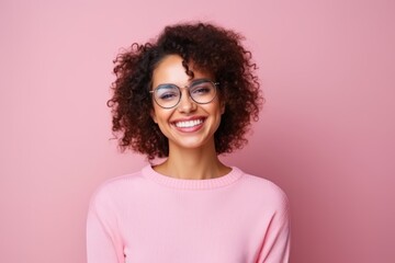 Wall Mural - Portrait of a beautiful young african american woman in glasses on pink background